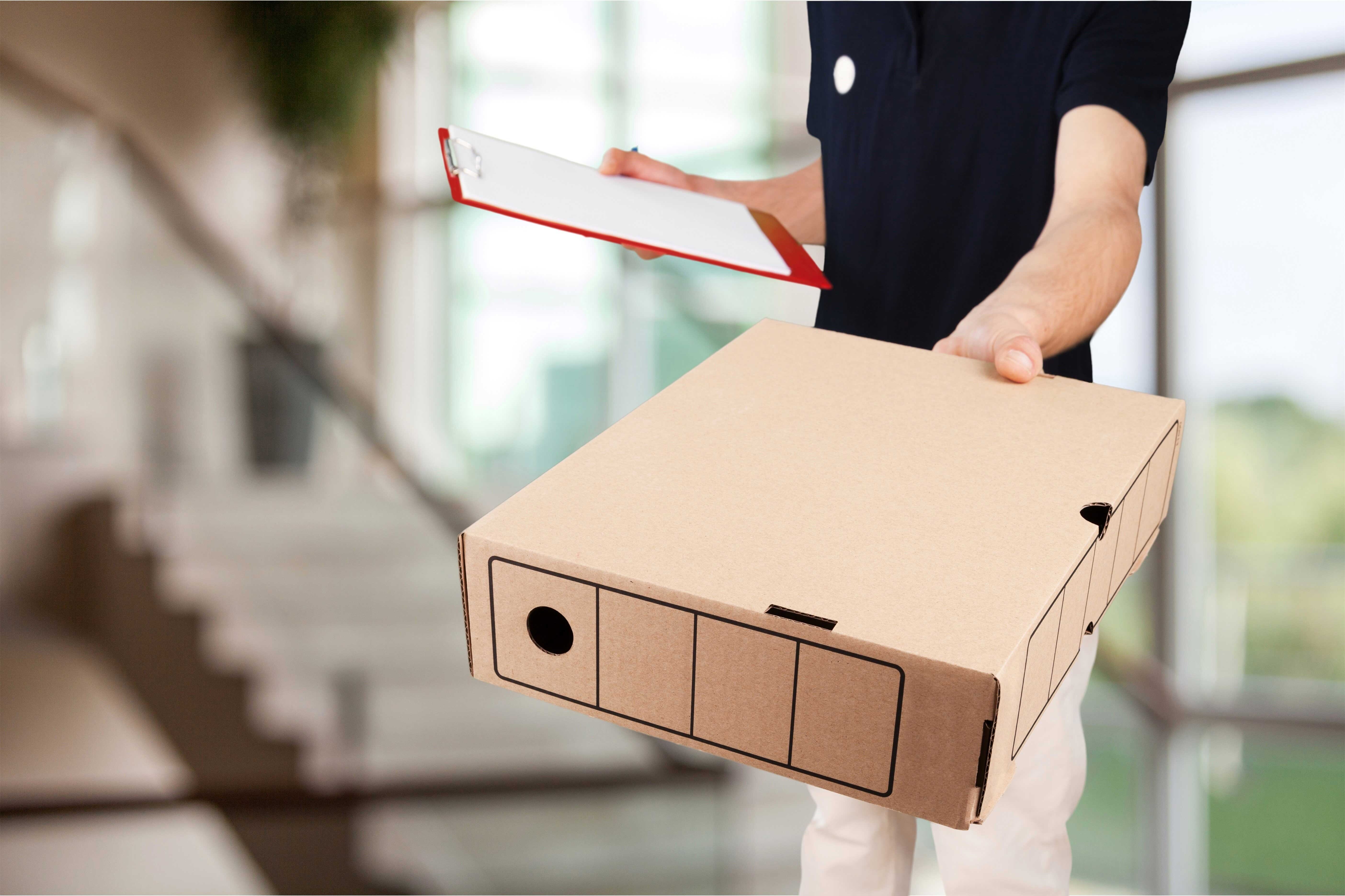 Плотный товар. Коробка в руках. Курьер с коробкой в руках. Доставщик с коробками в руках. Передает коробку.