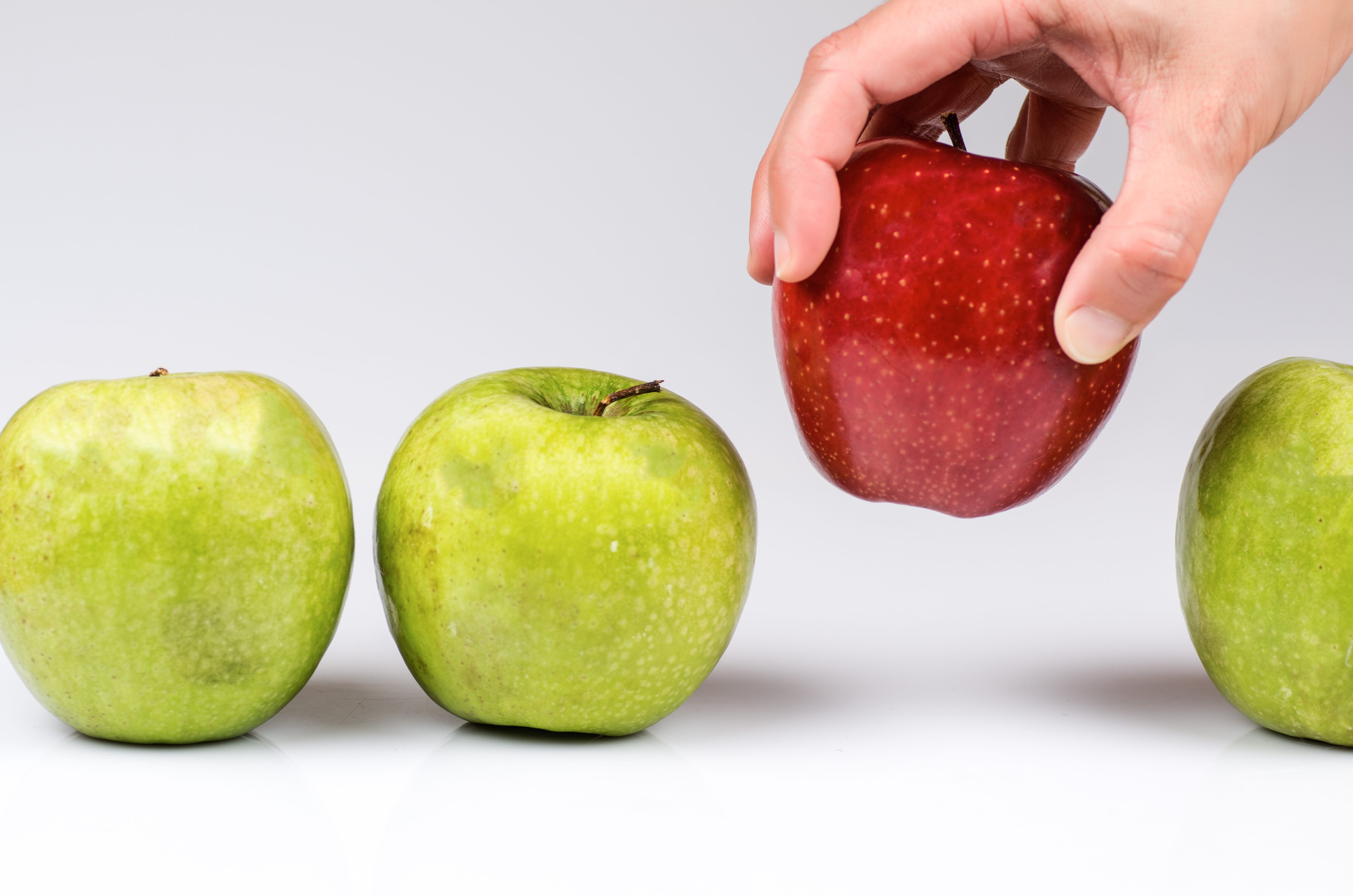 3 красных и одно зеленое яблоко. зеленое яблоко в руке. Apple choose. Apple choose. Apple choose.